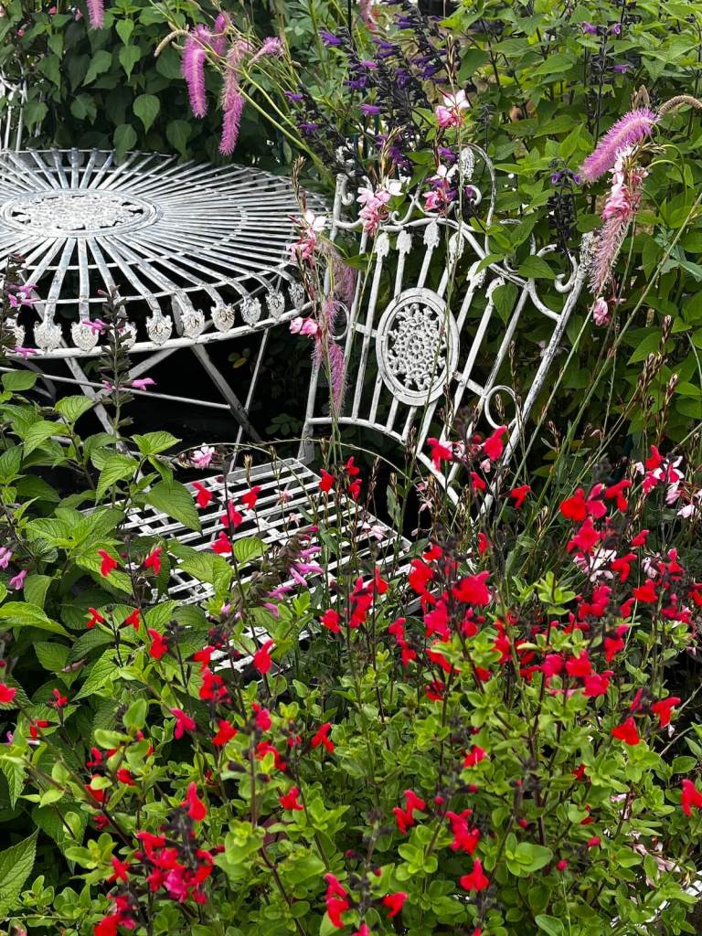 Ornate metal chair and table in flowers